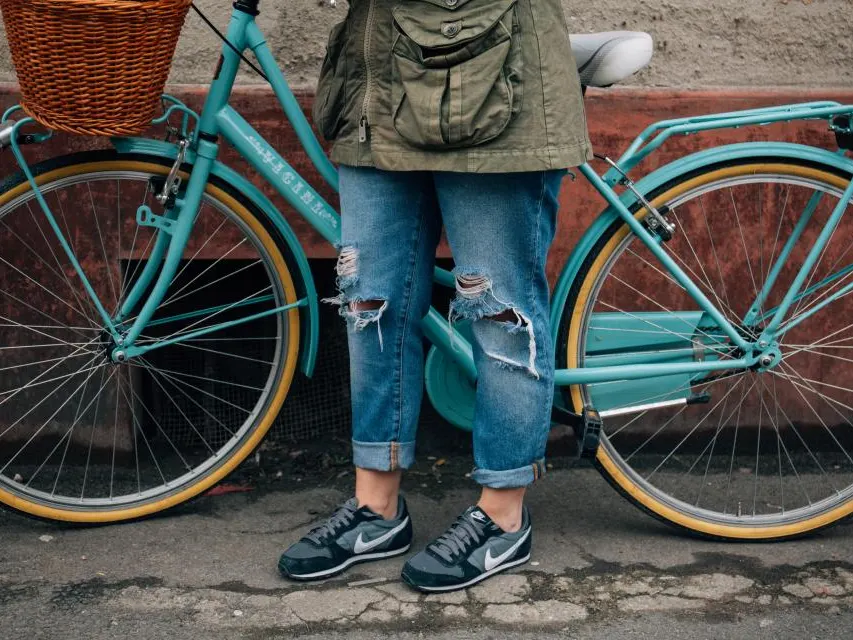 Pessoa ao lado de uma bicicleta com cesta